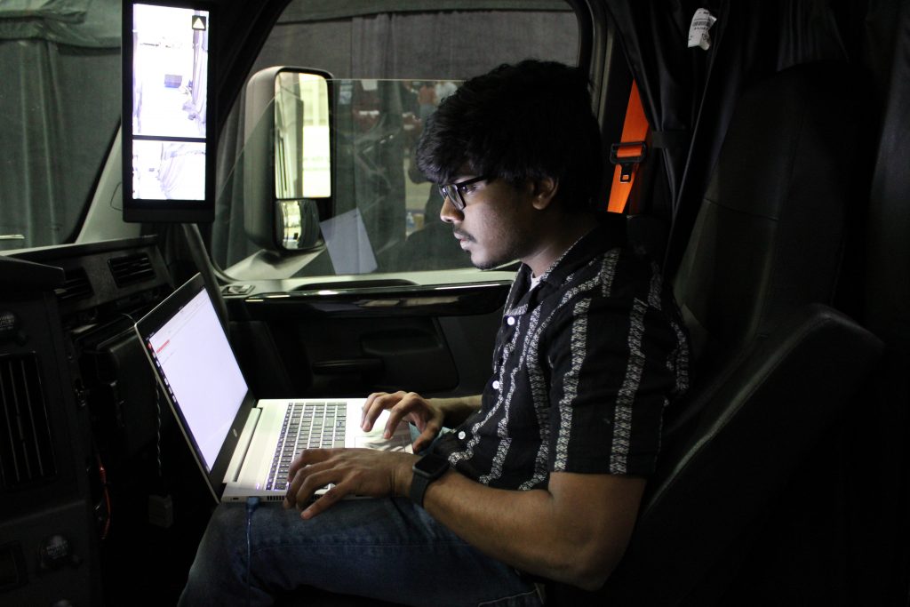 Student working on a computer in the cab of a truck at the CyberTruck Challenge.